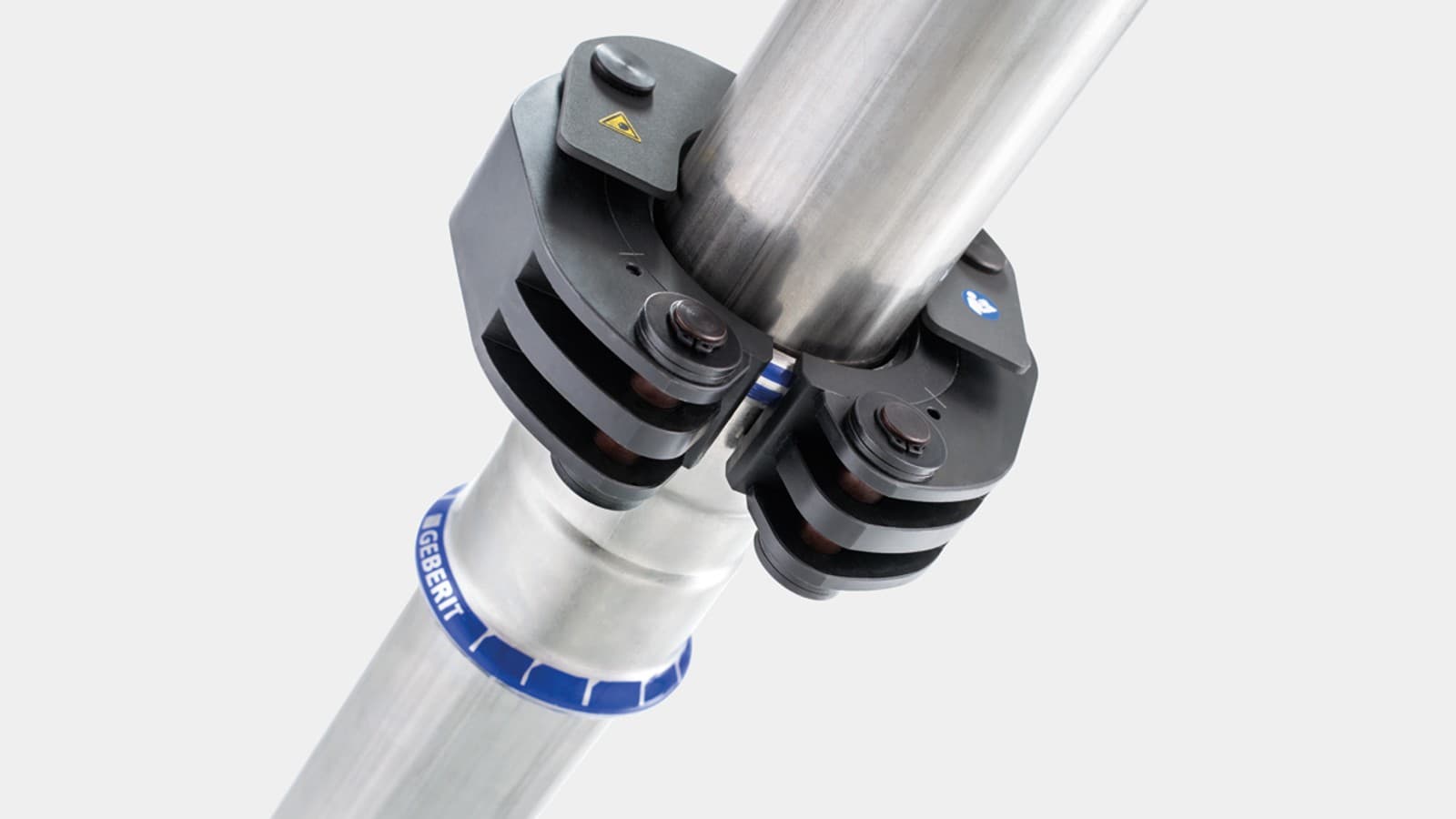 Salpamekanismi kiinnittää Geberit-puristuskauluksen Geberit Mapress -liittimeen Salpamekanismi kiinnittää Geberit-puristuskauluksen Geberit Mapress -liittimeen